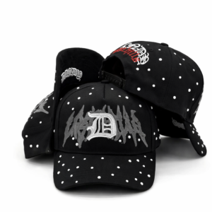 Black baseball caps with gothic embroidery and white stud embellishments on white background.
