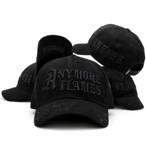 Black baseball caps with gothic “ANYMORE FLAMES” embroidery and tonal flame stitching on white background.